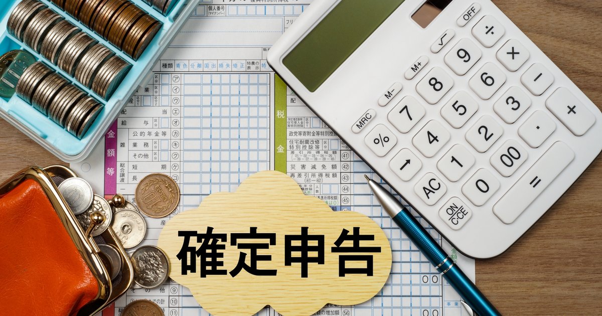 机の上に広げられた領収書と電卓と確定申告書類のイメージ